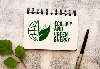 Between two sheets from a notebook on a green strip with the inscription - Ecology And Green Energy