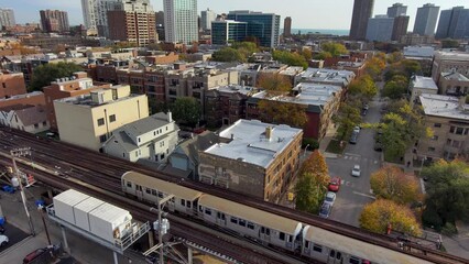 Wall Mural - panning aerial footage of train riding on the tracks with autumn trees, cars on the street and skyscrapers, hotels and office buildings in the city skyline in Chicago Illinois USA