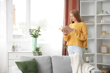 Poster - Young woman reading book at home