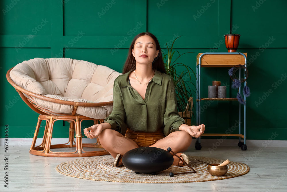 Young Asian woman with glucophone meditating at home