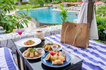 lunch at a restaurant looking out over the swimming pool, and dinner in a restaurant by the pool in Pattaya Thailand. snacks and spaghetti on a table