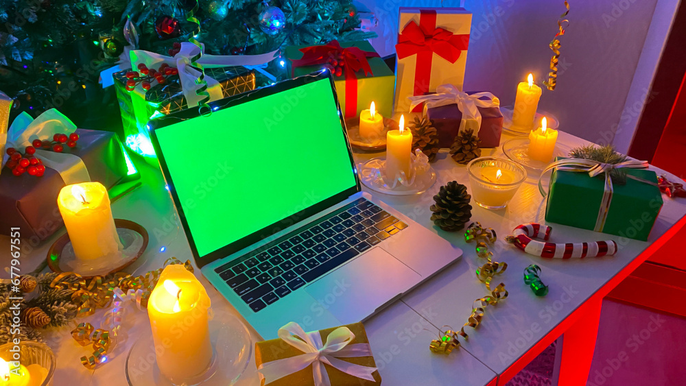 Beautiful Christmas table with a laptop with a green screen, New Year's ...