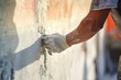 close up construction worker hand plastering on the white wall bokeh style background