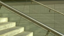 Close-up of stainless steel handrails with glass panels, modern stairway design elements.