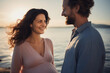 © toonsteb - a pregnant woman and man laughing on the beach bokeh style background