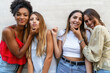 © Lomb - Four smiling friends having fun making silly faces against a light wall.