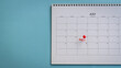 Calendar with word event and red pushpin. On blue desk background, copy space.