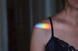 Rainbow sun glare on a woman's shoulder