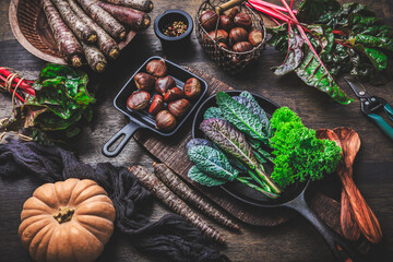 Wall Mural - Organic raw winter vegetables on kitchen table with carrots, chesnuts, chard, kale