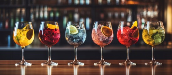 Sticker - Five vibrant gin tonic drinks in wine glasses on bar counter in establishment Copy space image Place for adding text or design