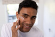 © WavebreakMediaMicro - Happy biracial man applying face cream in bathroom at home