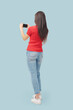 © StockPhotoPro - Young woman using smartphone back view