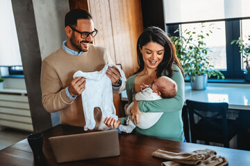 Wall Mural - Portrait of parents and newborn baby. Father and mother kiss and hug a beautiful newborn child. .