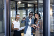© Wavebreak Media - Happy diverse male and female colleagues brainstorming at glass wall with tablet, copy space