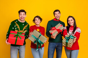  Photo of four buddies prepare gift wish dream packages buy on christmas discounts isolated over bright color background