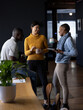 © Wavebreak Media - Happy diverse male and female colleagues with tablet having coffee and talking standing in office