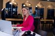 © Wavebreak Media - Smiling caucasian casual businesswoman using laptop sitting at desk in office, copy space