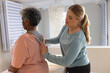 © Wavebreak Media - Caucasian female physiotherapist massaging senior african american female patient, copy space