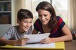 © Stavros - Mom helps her son do homework sitting at table writing in notebook right answer. Boy asks mother to help with homework at table with laptop. Mom in cozy modern apartment helps daughter with lessons