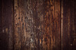 Background of old vertical dark wooden planks. Weathered wooden structure.
