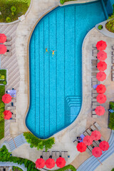 Wall Mural - view from above at a couple swimming in an infinity pool on a luxury vacation in Thailand, man and woman in a pool of a luxury hotel in Thailand on vacation, drone aerial view