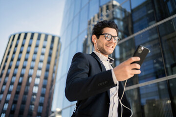 Wall Mural - A man reads a message with glasses in a business suit going to work in the office. A businessman uses a phone app from a partner. Uses the bank's application to get a business loan.