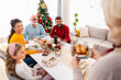 Woman bringing chicken to the table for family Christmas dinner
