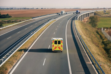 Wall Mural - Fast moving ambulance car of emergency medical service on highway. Themes health care, rescue and urgency..