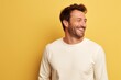 © CogniLens - Portrait of a joyful man in his 30s sporting a long-sleeved thermal undershirt against a pastel yellow background. AI Generation