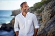 Portrait of a blissful man in his 40s wearing a simple cotton shirt against a rocky shoreline background. AI Generation