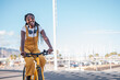 © Ivan - Young woman riding a yellow bicycle and smiling on a ride through the city. Concept: lifestyle, outdoors.