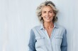 Portrait of a blissful woman in her 50s sporting a versatile denim shirt against a plain white digital canvas. AI Generation