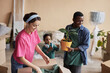 © Seventyfour - Happy young multiethnic woman unpacking box with household things while her husband holding flowerpot with domestic plant