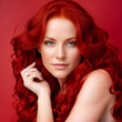 Beautiful redhead woman posing on scarlet background