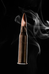 Rifle bullet in smoke on black background.