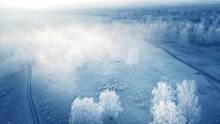 White Frost-covered Trees In Winter Forest At Foggy Sunrise. Aerial View. Road In The Mountains. Clouds Over The Mountains And Forest. Winter Landscape
