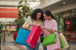 © puhhha - A woman enjoys fashion shopping at the mall, happy with her discount and sale.