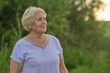 © yavdat - The gentle smile of a mature woman outdoors at sunset. Highlights the growing focus on nature's role in enhancing quality of life for the aged.