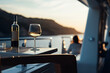 Sunset wine affair: Romantic summer by the sea, celebrating with glasses, luxury, and a coastal view.