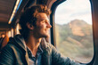 Man on a train looking through the window with pensive look on his face. A travel concept, chasing his dreams