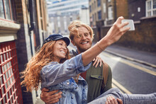 Happy Young Couple Taking Selfie Together In City