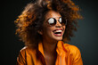 © Georgii - Young beautiful mixed race woman wearing yellow turtleneck sweater. Dark-skinned girl with curly afro hairstyle in sunglasses