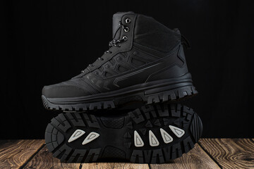 Men's winter boots in black on a dark background.