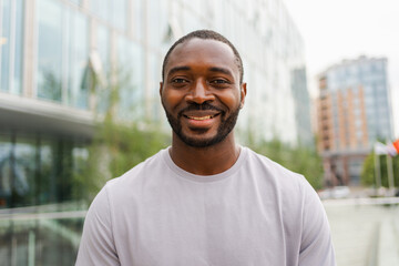 Wall Mural - Happy african american man smiling outdoor. Portrait of young happy man on street in city. Cheerful joyful handsome person guy looking at camera. Freedom happiness carefree happy people concept