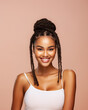 © Balica - Half-length portrait of young, happy, smiling African black model girl with pigtail hairstyle and in white tank top with straps looks at the camera isolated against soft pastel pink background
