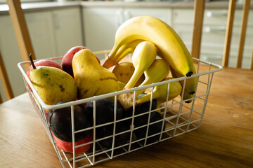 Canvas Print - Basket with fresh fruits on table in kitchen