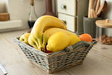 Wall Mural - Basket with fresh fruits on table in kitchen