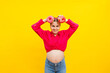 Smiling pregnant woman with sweet cakes in her hands on a yellow background. Delicious sweet donuts in the hands of a woman. Harmful food
