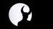 Silhouette of horned devil demon figure on white circle background cutout 