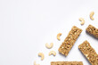Tasty granola bars and cashew nuts on white background, flat lay. Space for text